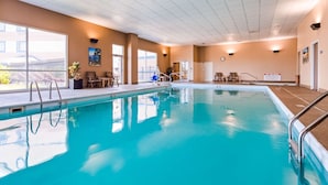 An indoor swimming pool with clear water, surrounded by lounge chairs and a sunlit area with large windows. - Best Western Plus Brandywine Inn & Suites (Monticello)
