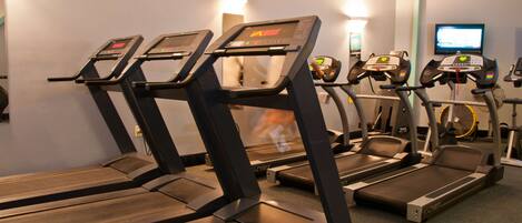Un gimnasio con cintas de correr y bicicletas estáticas.