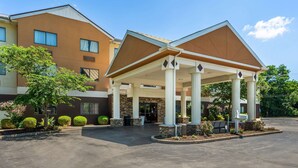 A hotel entrance with a covered waiting area, columns, and a parking lot. - Best Western Plus Georgetown Corporate Center Hotel (Georgetown)