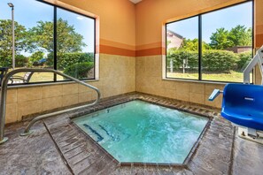 Un jacuzzi con vistas al exterior, una barandilla metálica y una silla azul.