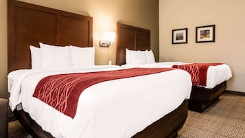 Relax in this inviting room with a large bed, wall-mounted lamp, and framed artwork.