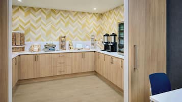 A modern kitchen with wooden cabinets, a white countertop, and a herringbone-patterned backsplash.