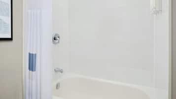 Un baño moderno con bañera, ducha y barras de apoyo.