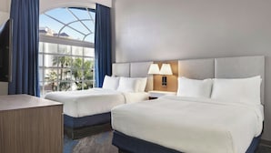A hotel room with two beds, a desk, a lamp, and a view of palm trees. - City Express by Marriott Port Hope Cobourg (Port Hope)