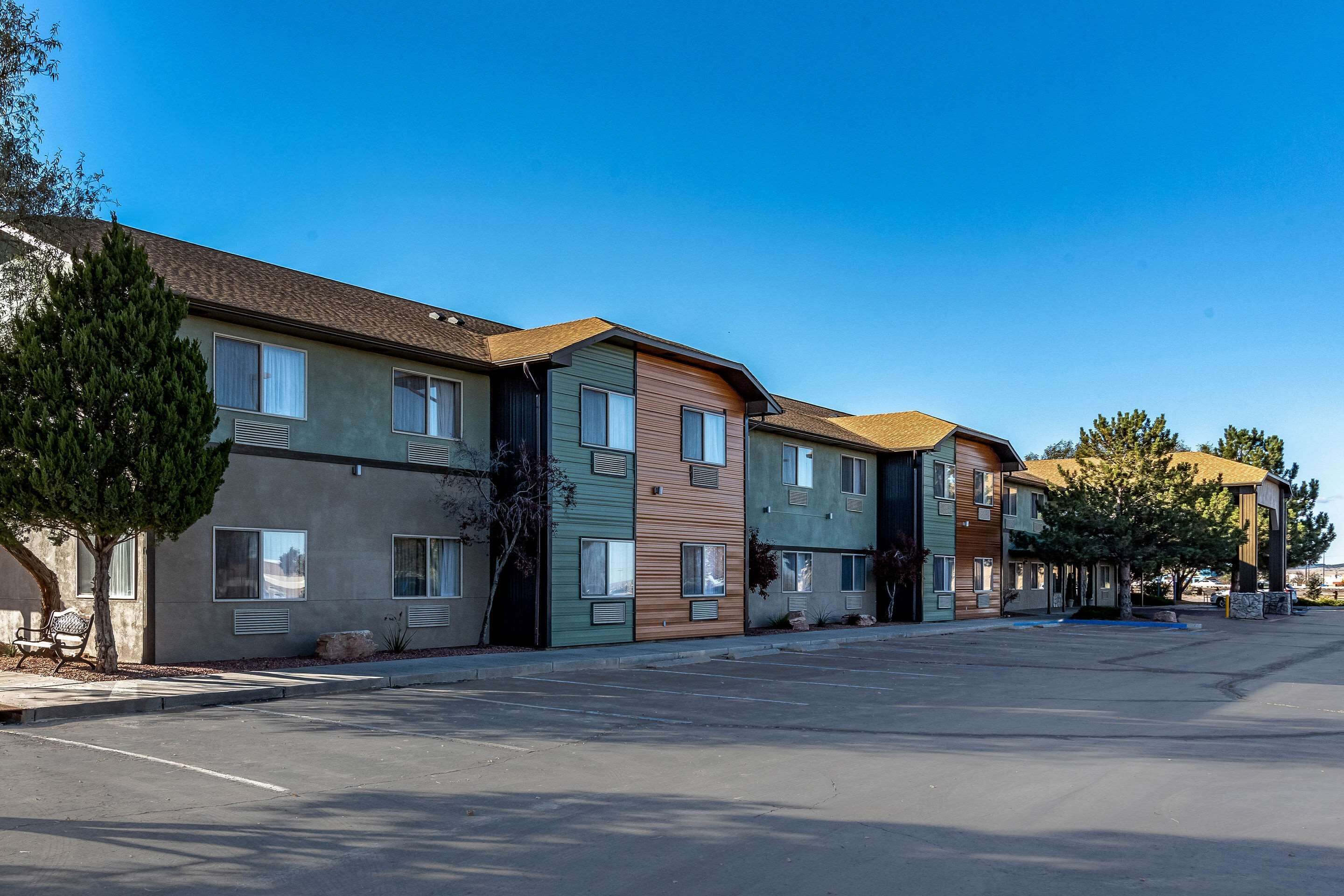 A row of modern multi-story buildings with a parking lot in front.