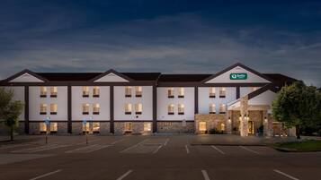 A multi-story hotel with a modern design, featuring a prominent sign for Quality Inn & Suites.