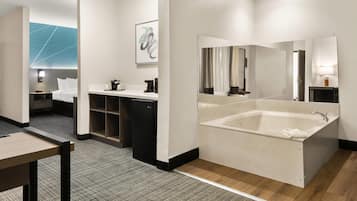 Un baño de hotel moderno con una bañera grande, un lavamanos doble y un espejo.