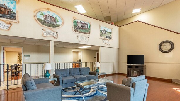 A spacious lobby with a modern sofa set, a glass coffee table, and a large clock on the wall. - Quality Inn Burkeville Hwy 360 & 460 (Burkeville)