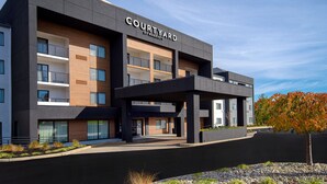 A multi-story hotel named 'Courtyard by Marriott' with a modern architectural design, featuring balconies and a covered entrance area. - Courtyard by Marriott Cincinnati Airport (Erlanger)
