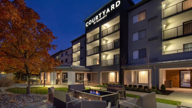 A Courtyard by Marriott hotel with outdoor seating, a fire pit, and a landscaped garden. - Courtyard by Marriott Cincinnati Airport (Erlanger)