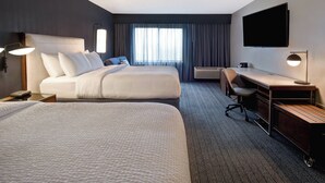 A hotel room with two beds, a desk, a chair, a flat-screen TV, and a window with curtains. - Courtyard by Marriott Cincinnati Airport (Erlanger)