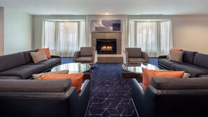 A modern living room with a fireplace, two sofas, and a coffee table. - Courtyard by Marriott Cincinnati Airport (Erlanger)