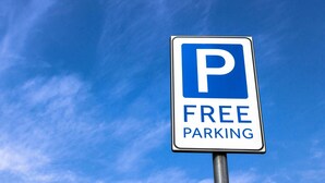 A parking sign with a blue 'P' and the words 'FREE PARKING' against a clear blue sky. - Gray Inn and Suites (Gray)