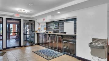A modern kitchen with a glass door entrance, a sink, and a patterned rug.