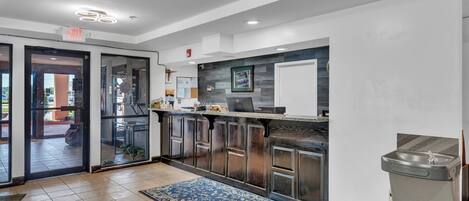 A modern kitchen with a glass door entrance, a sink, and a patterned rug.