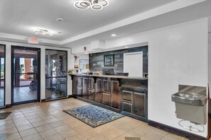 Une cuisine moderne avec une porte d’entrée en verre, un évier et un tapis à motifs.