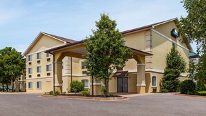 A hotel with a yellow facade, multiple balconies, and a covered entrance. - Days Inn by Wyndham Kansas City International Airport (Kansas City)