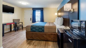 A hotel room with a bed, a desk, a chair, a television, a microwave, and a refrigerator. - Econo Lodge West Yarmouth on Cape Cod (West Yarmouth)