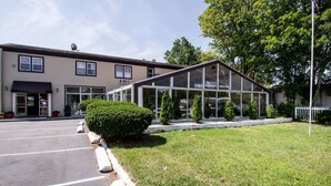 A building with a glass entrance and a covered patio area. - Econo Lodge West Yarmouth on Cape Cod (West Yarmouth)
