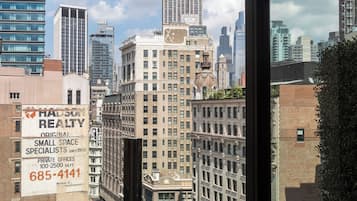 A view of the Empire State Building from a window overlooking a cityscape.