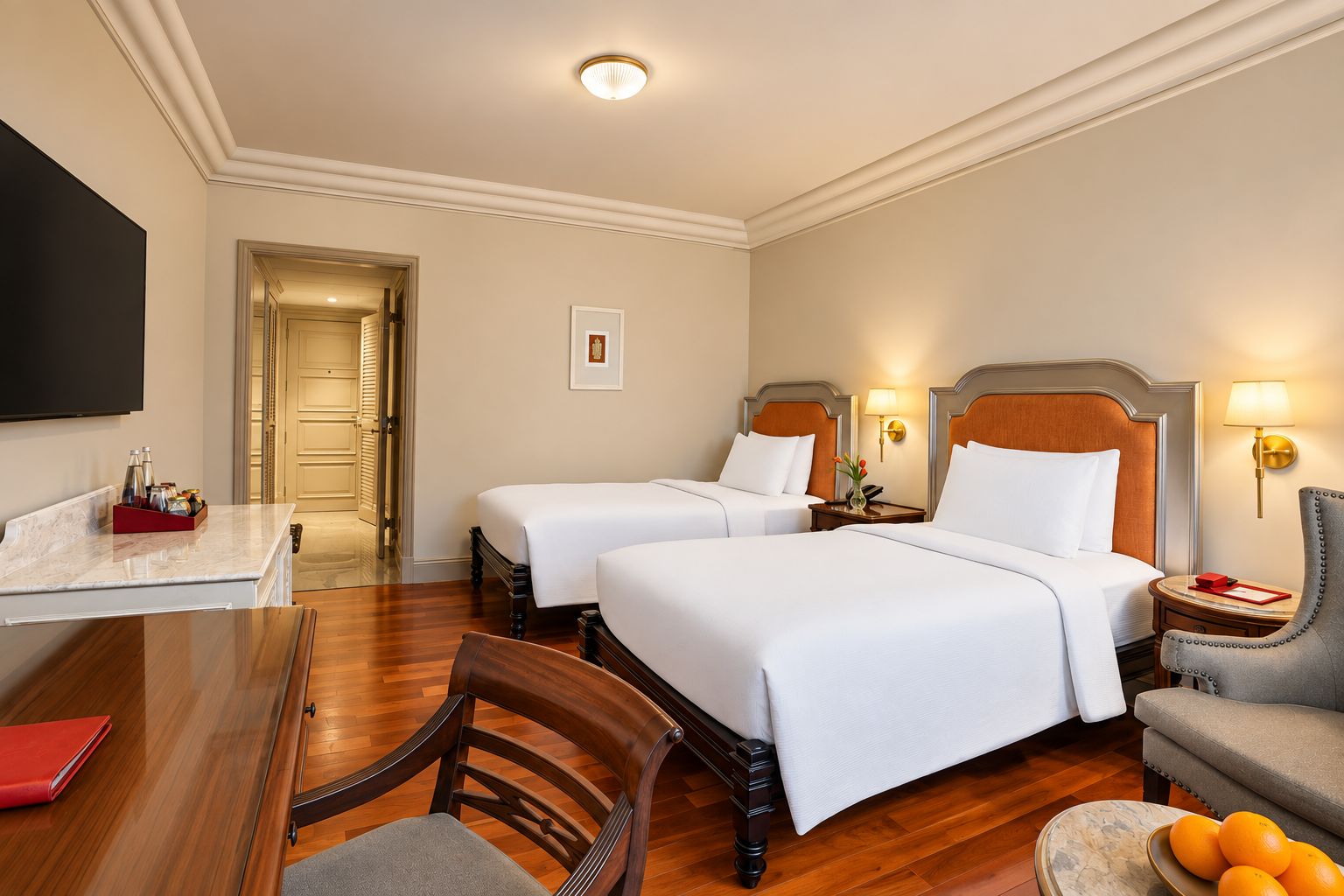Une chambre d’hôtel avec deux lits, un bureau, une chaise et une table à manger.