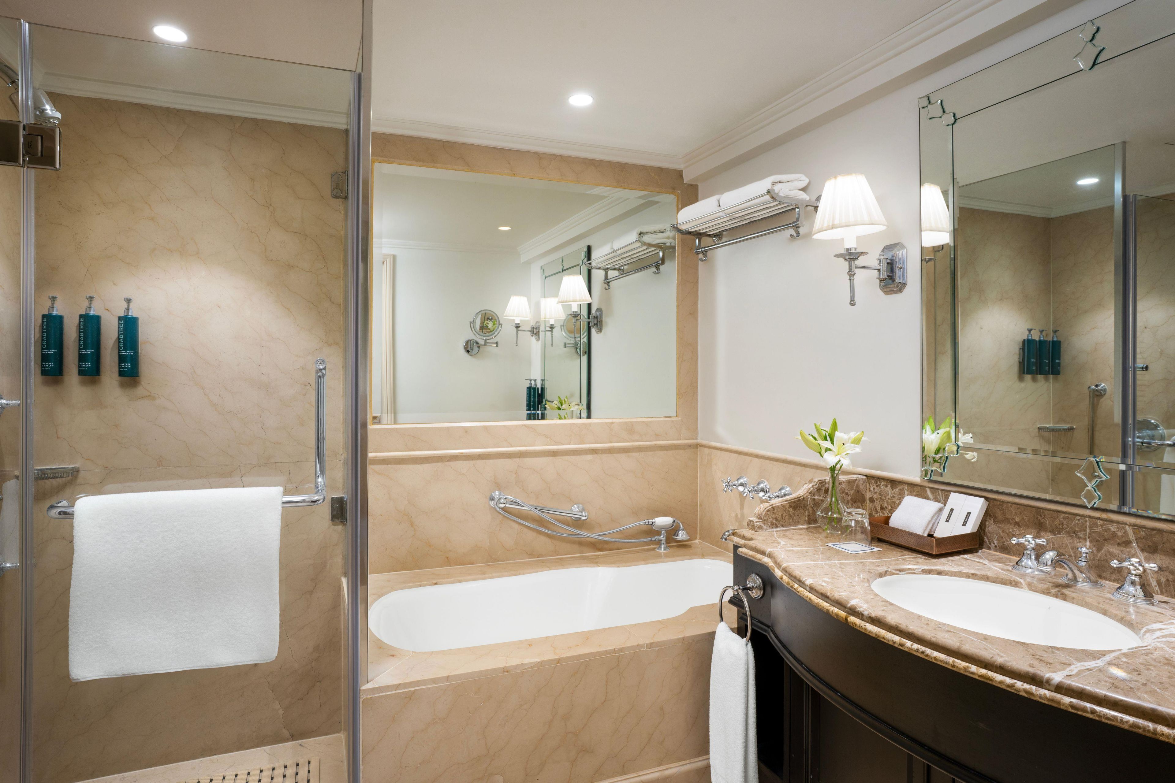 A modern bathroom with a glass shower enclosure, a double sink vanity, and a large mirror.