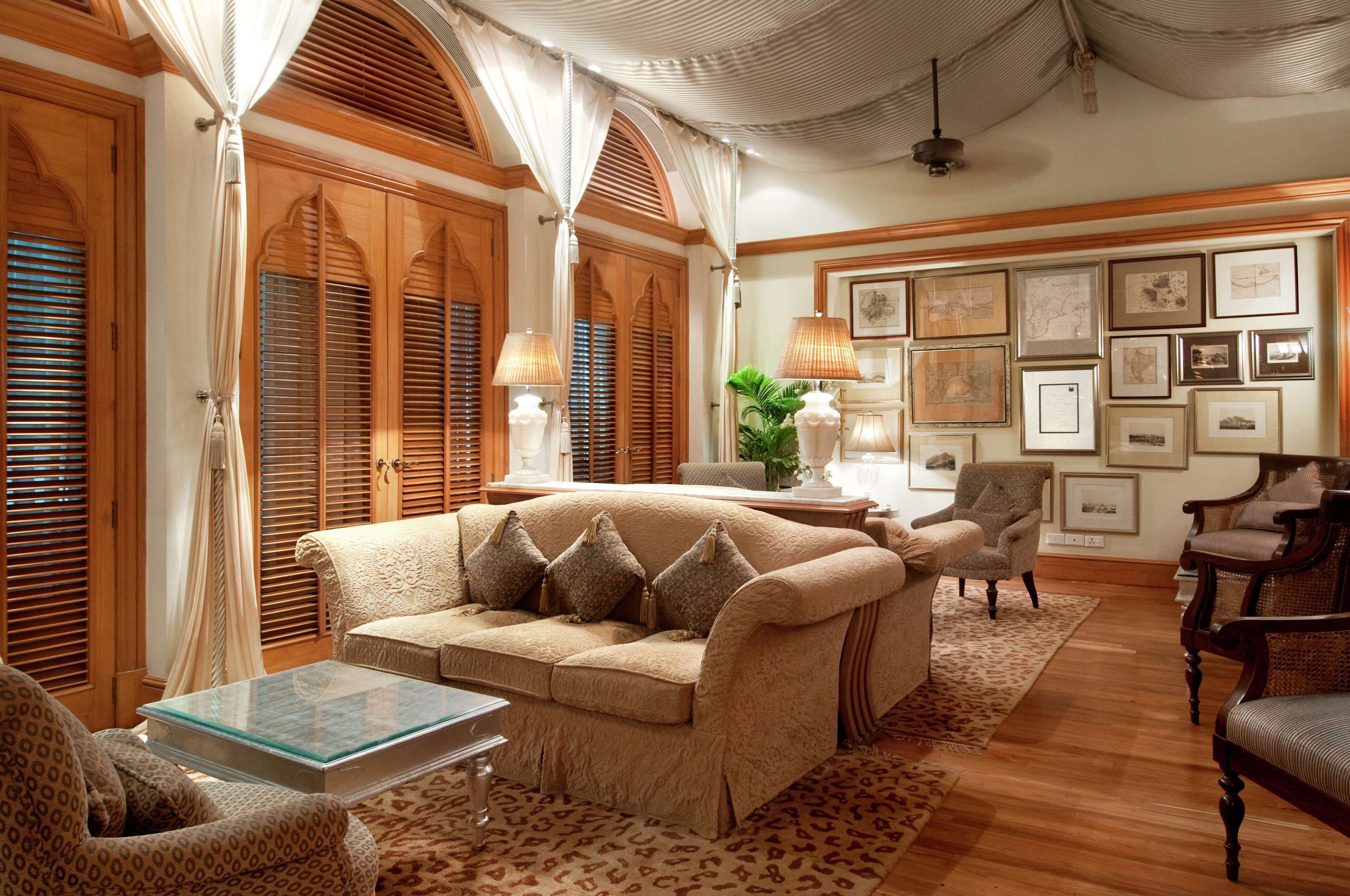 A traditional living room with a sofa, armchairs, a coffee table, and a patterned rug.