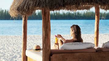 En privat strand, hvidt sand, gratis strandhytter, liggestole