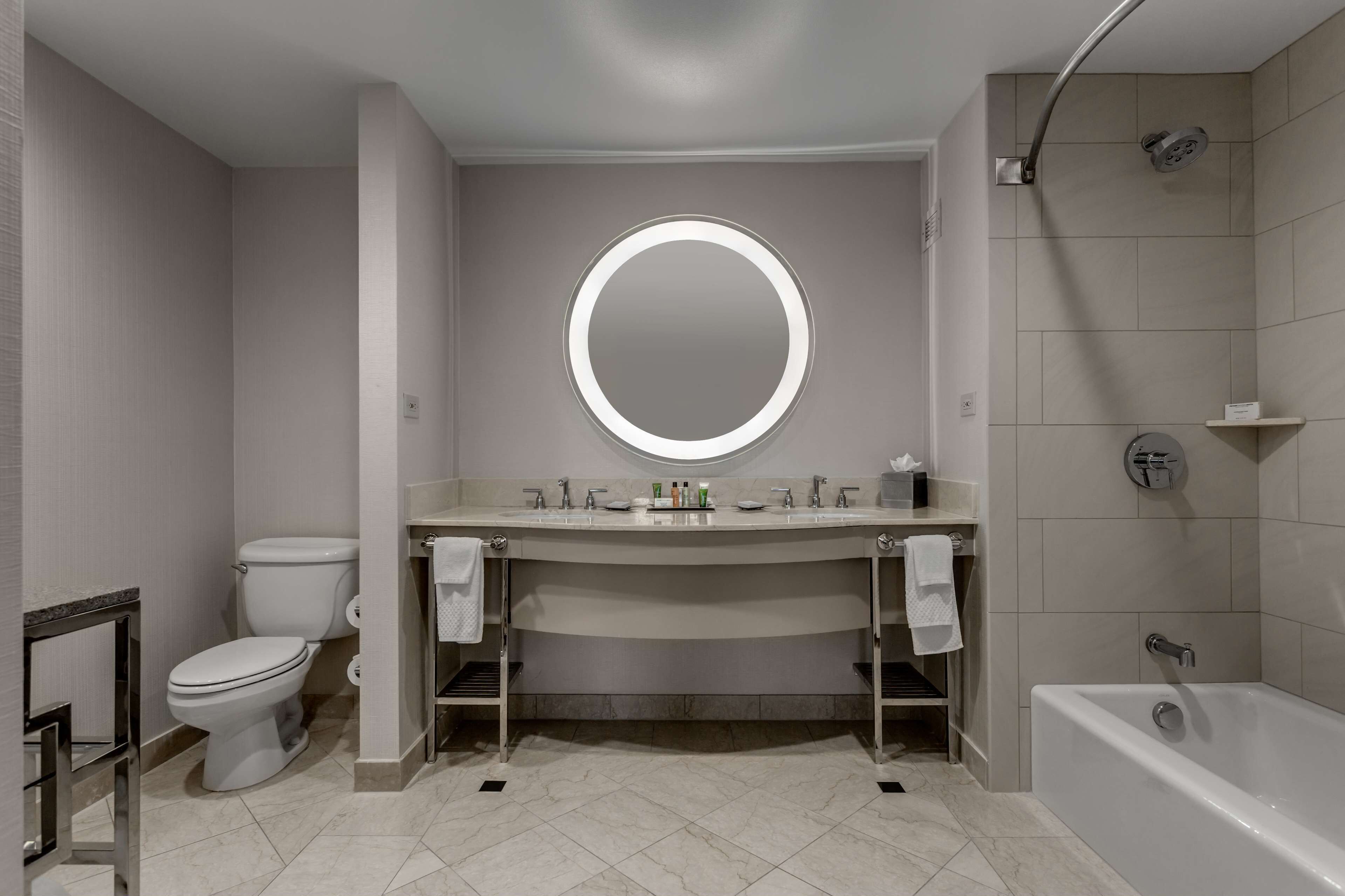 Een moderne badkamer met toilet, wastafel en bad.