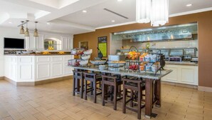 A spacious kitchen with white cabinetry, a central island with bar stools, and a breakfast bar. - Hilton Garden Inn Wichita (Wichita)