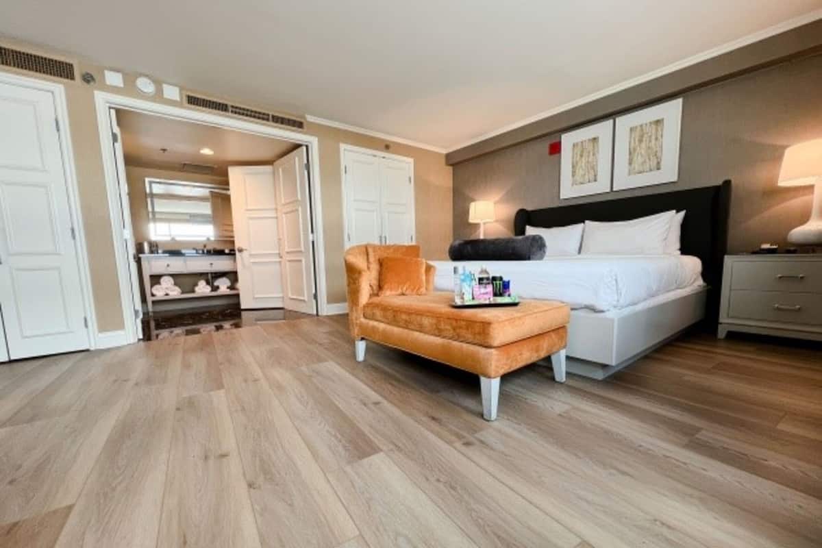 Una habitación de hotel con cama, mesita de noche, escritorio, silla y armario.
