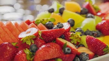 Eine Auswahl frischer Früchte, darunter Erdbeeren, Blaubeeren und Melonenscheiben.