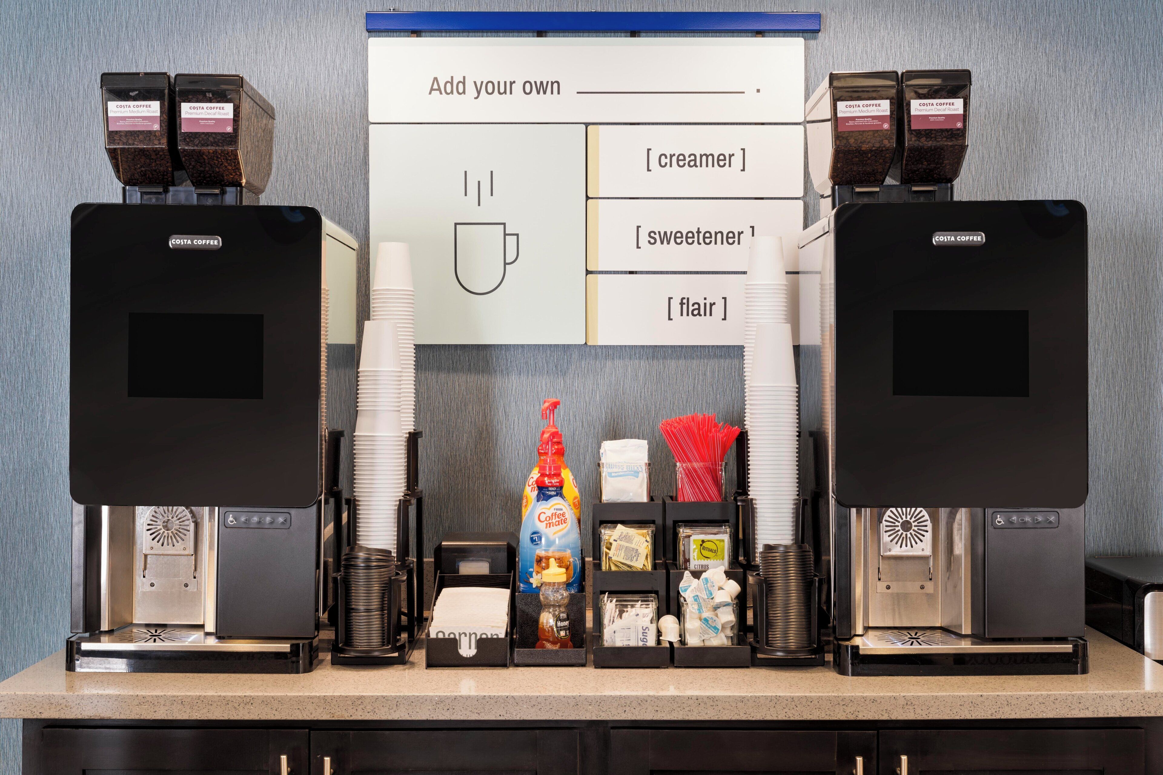 A coffee station with two coffee machines, a coffee maker, and various coffee-related items.