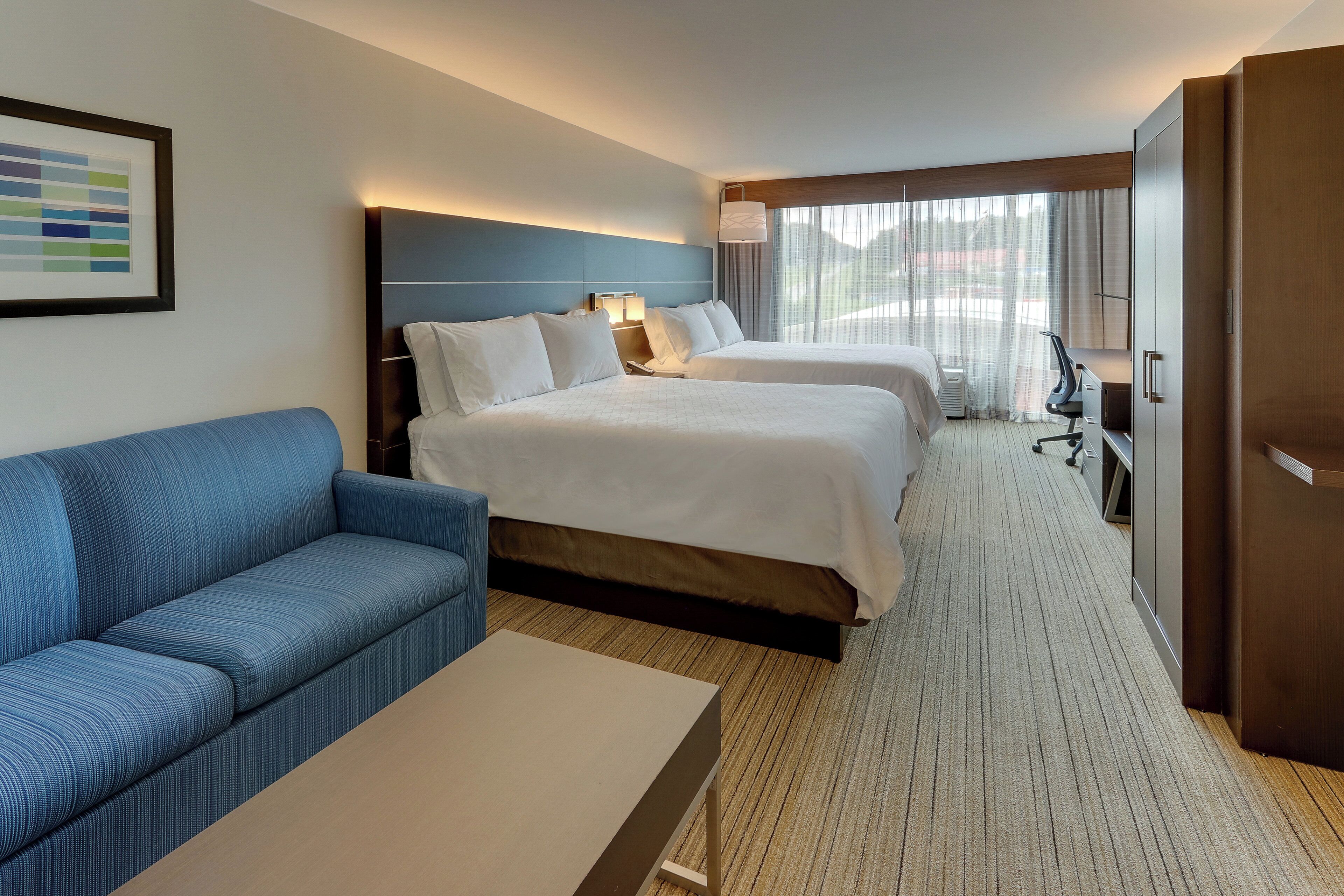 Une chambre d’hôtel avec un lit, un canapé, un bureau et une télévision.