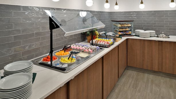 Ein Bereich mit Buffet und einer Auswahl an Speisen, darunter Obst, Gemüse und Brot.