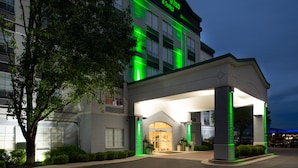 Ein Holiday Inn & Suites Hotel mit moderner Fassade, großen Fenstern und einladendem Eingang.