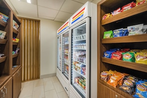 Un área de venta de aperitivos con diversas opciones y un refrigerador.