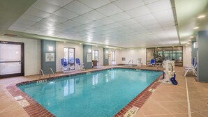An indoor swimming pool with clear water, surrounded by lounge chairs and exercise equipment. - Holiday Inn Express Hotel & Suites Louisville East by IHG (Louisville)