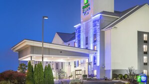 A Holiday Inn Express & Suites hotel with a modern design, featuring a prominent sign, a covered entrance, and a landscaped area with trees. - Holiday Inn Express Hotel & Suites Louisville East by IHG (Louisville)