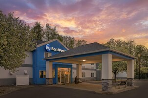Un hotel Best Western con fachada azul, entrada cubierta y zona de estacionamiento.