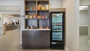 A self-service kiosk with snacks and beverages, including chips and soda, in a clean, modern setting. - Best Western Brockport Inn & Suites (Brockport)