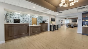 A modern hotel lobby with a reception desk, seating area, and a large chandelier. - Best Western Brockport Inn & Suites (Brockport)