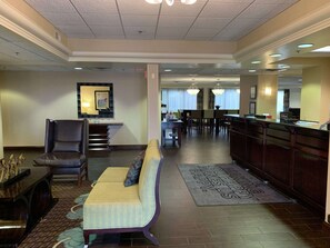 A hotel lobby with a reception desk, seating area, and a dining area. - Hampton Inn Danville (Danville)