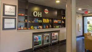 A snack bar with a variety of packaged snacks and beverages, a sign with the word "OH" and a "TREATS" sign above it, and a refrigerator with drinks and snacks. - Hampton Inn Medina (Medina)