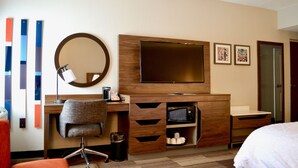 A hotel room with a wooden desk, a chair, a television, a mirror, and a bed. - Hampton Inn Medina (Medina)