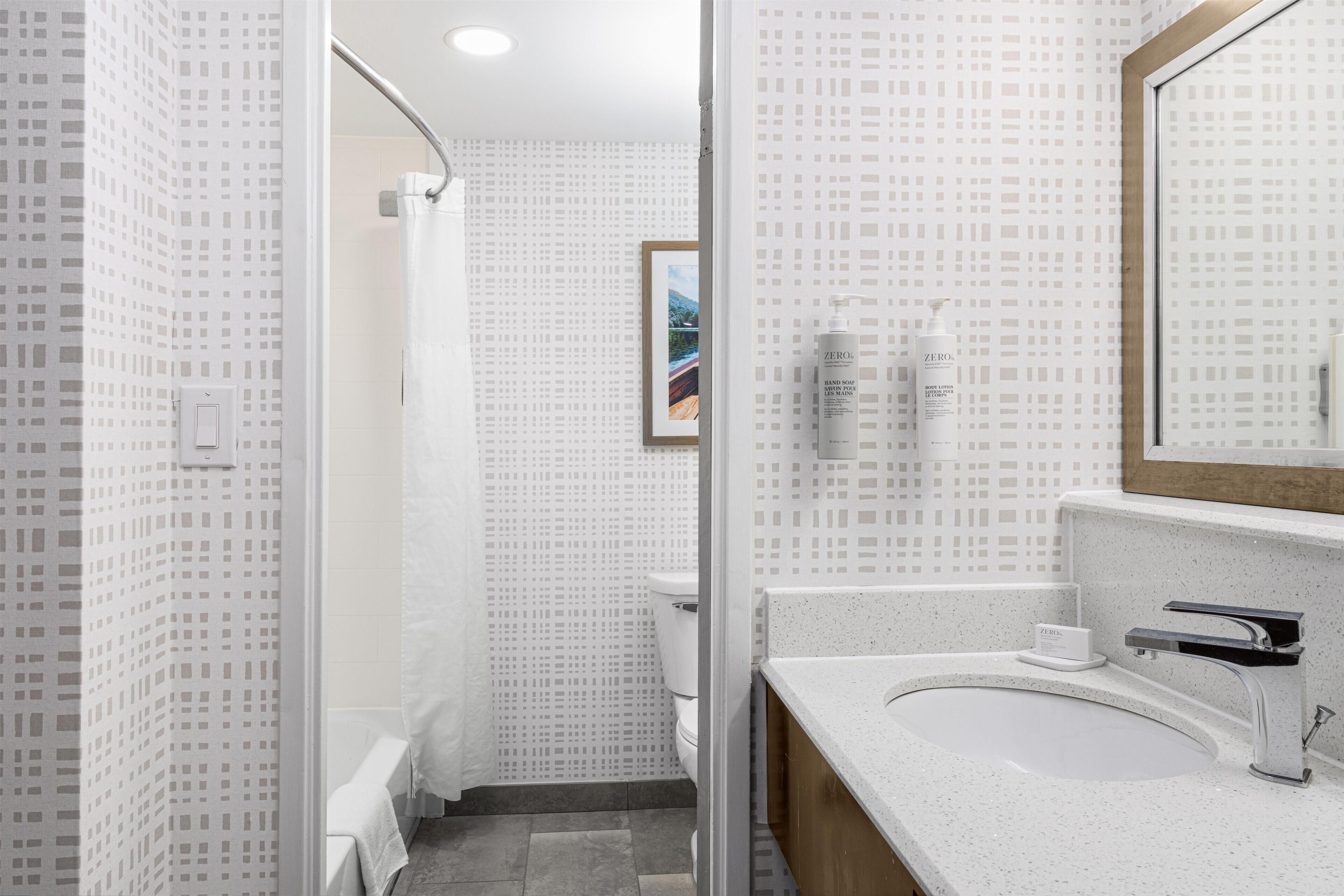 Un baño moderno con ducha, lavabo y espejo.