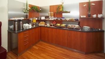 A kitchen with wooden cabinets, a stainless steel countertop, and various kitchen appliances.