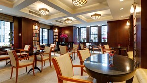 Une bibliothèque spacieuse, dotée de nombreuses tables et chaises, de grandes fenêtres et d’appareils d’éclairage décoratifs.