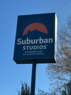 A sign for Suburban Studios, indicating it is an extended stay hotel by Choice Hotels.