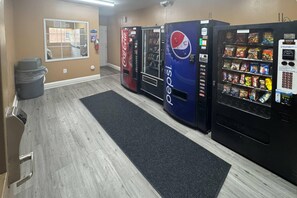 A hotel lobby with vending machines, a trash bin, and a window with a view. - Suburban Studios near University of North Carolina-Charlotte (Charlotte)